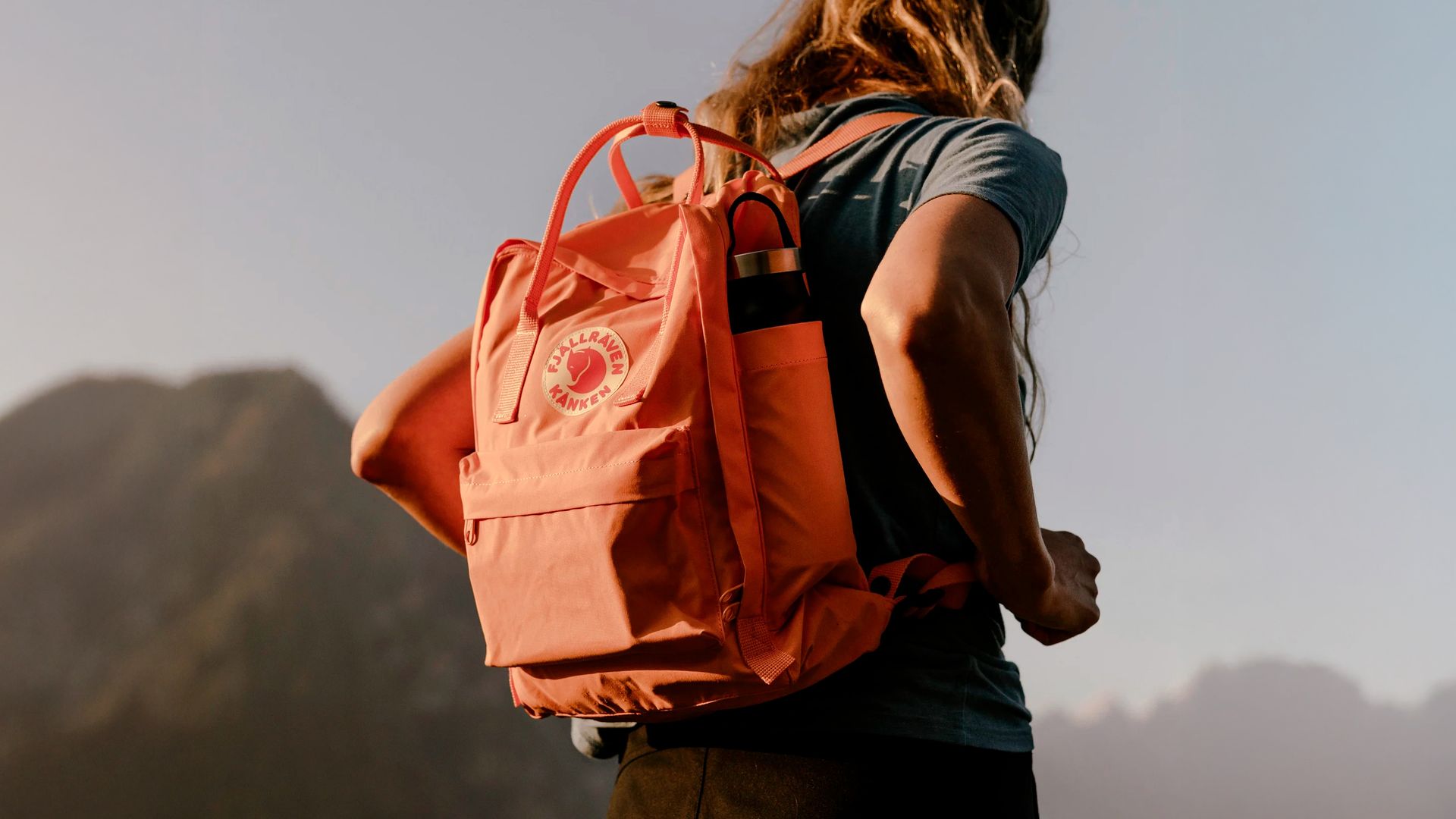 Mujer en la montaña con una mochila Fjallraven Kanken