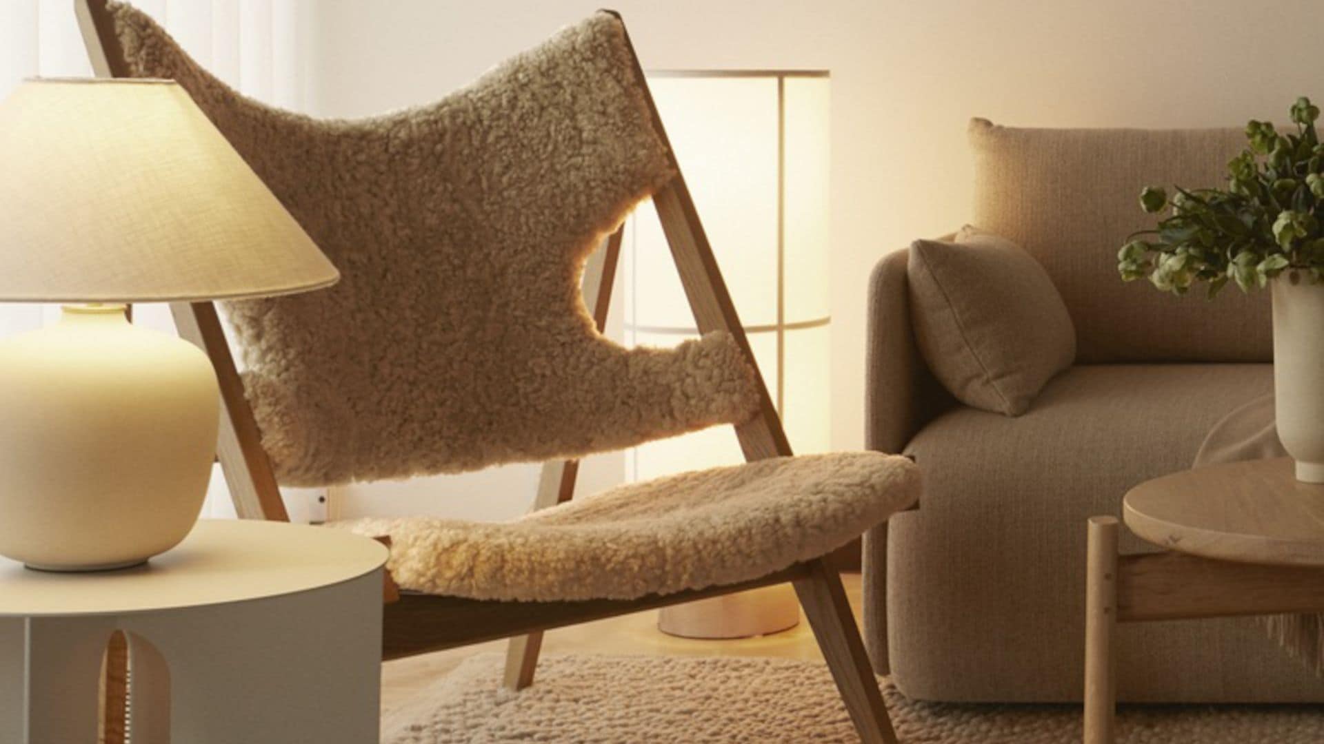 Salón con sofá beige, sillón de lana bouclé, lámpara de pie y de sobremesa