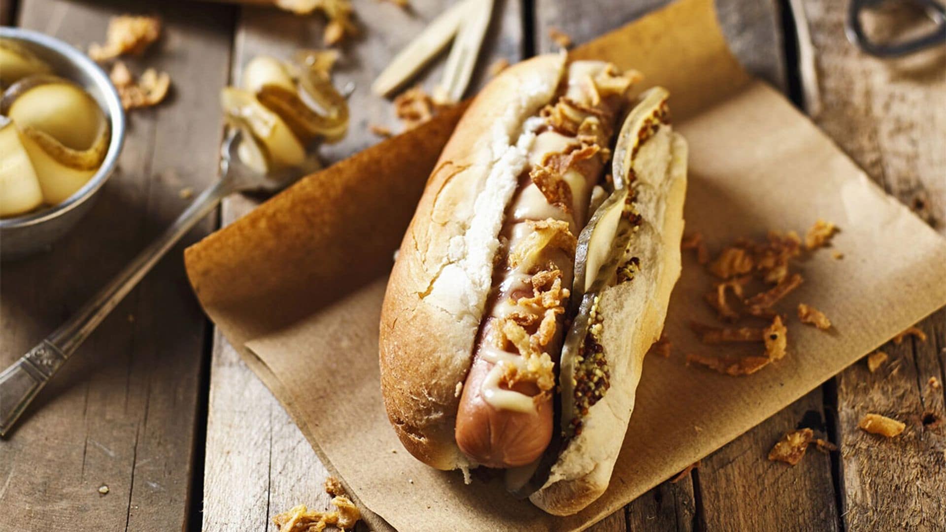 Perrito caliente con queso cheddar y cebolla crujiente