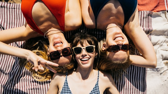 Mujeres en bañador disfrutando de la playa, tumbadas en la arena