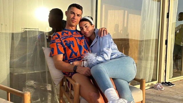 Plano medio de Cristiano y Georgina abrazados sentados en una silla 
