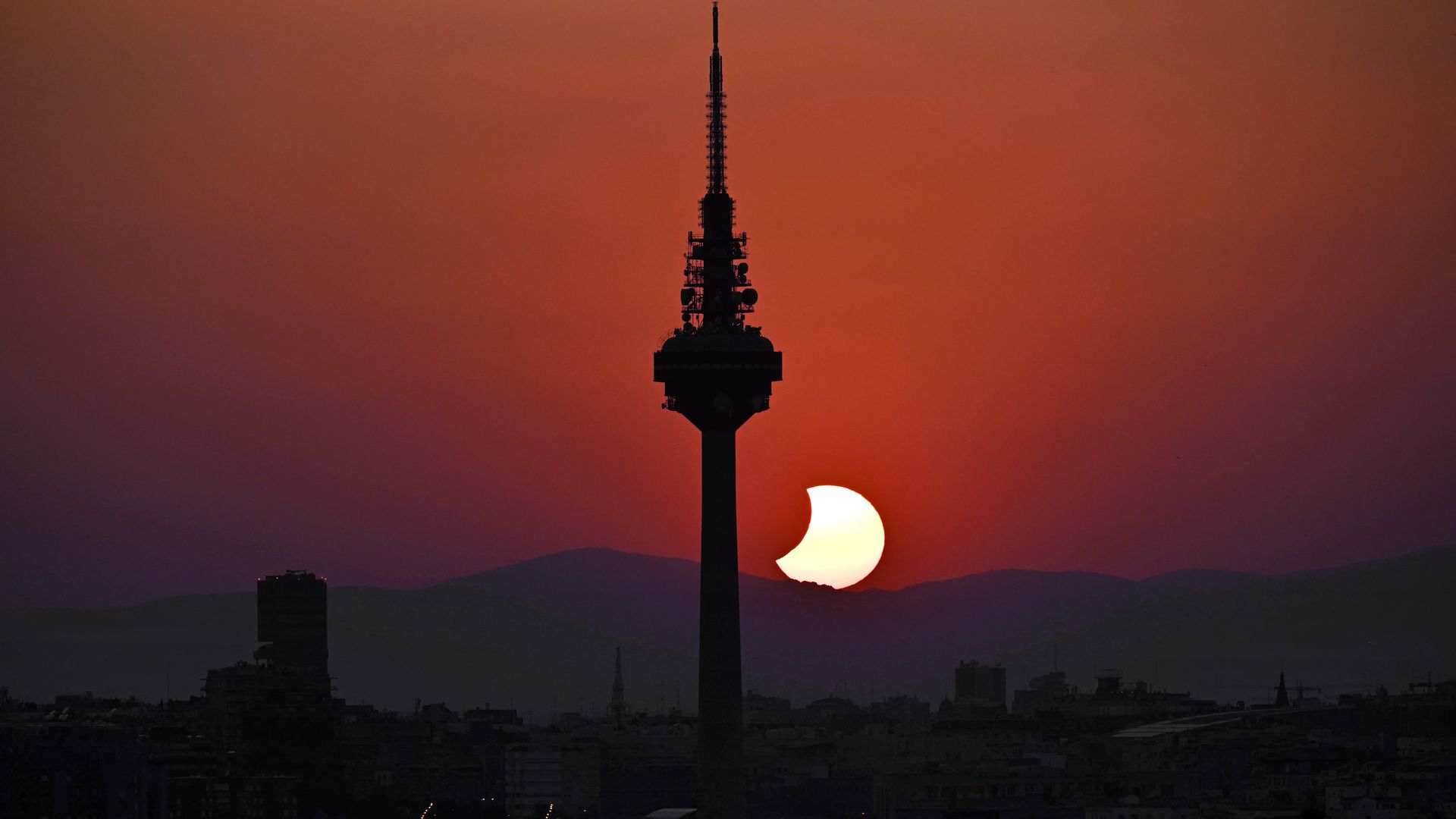 La Luna comienza a descubrir el Sol tras Torrespaña, el popular ‘Pirulí’, durante los últimos instantes del eclipse vistos desde el mirador de la Cuña Verde, en Madrid. Una espectacular estampa del momento en el que la luz fue recuperando poco a poco el protagonismo después de la oscuridad que sorprendió a la capital.