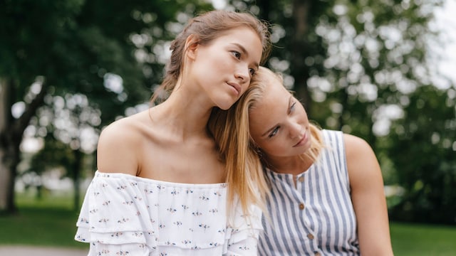 Mujer apoyada en el hombro de su amiga