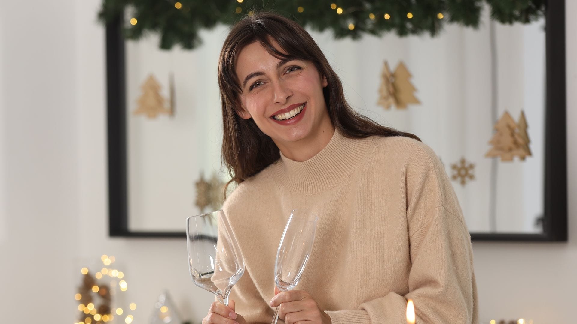 Una mujer sonriendo poniendo una mesa de Navidad