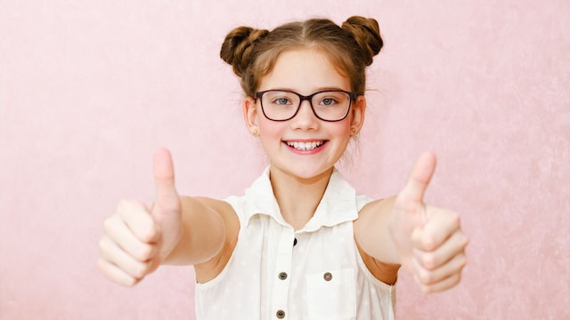 Niña con gafas haciendo símbolo de OK