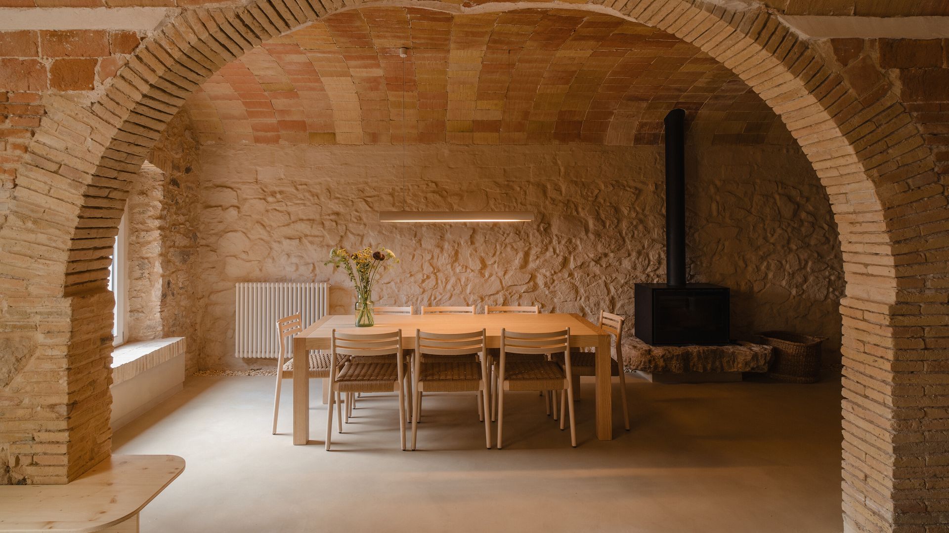 Comedor casa antigua con bóveda, mesa de comedor de madera, sillas de comedor, paredes de piedra 