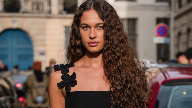 Sarah Lysander con vestido negro y pelo rizado en la Semana de la Moda de París