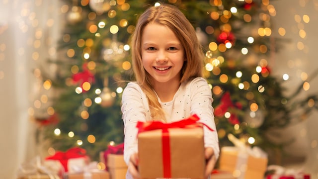 Niña dando un regalo de Navidad