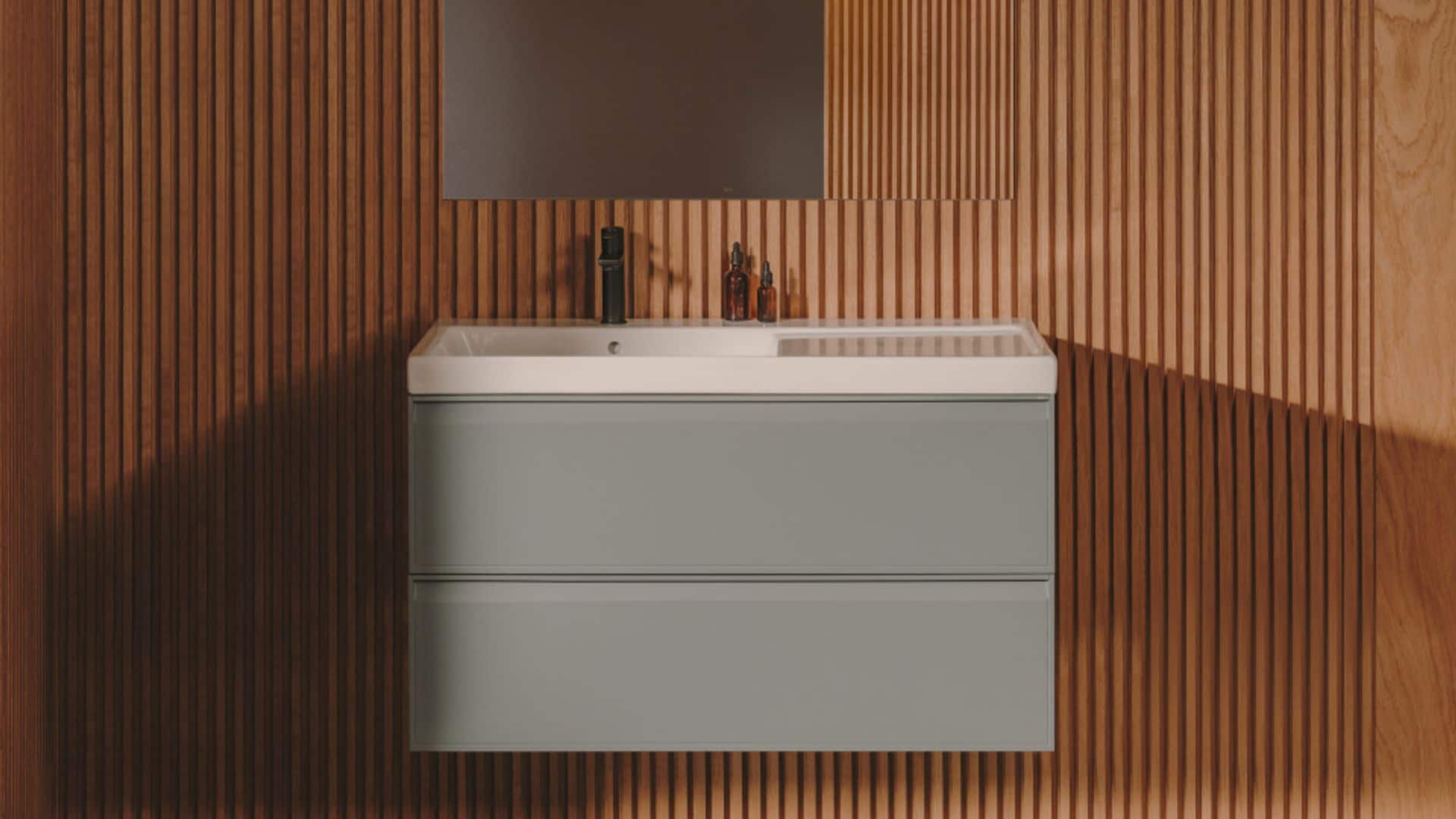 Baño con paredes de madera acanalada, mueble bajolavabo suspendido de color gris, con encimera integrada, espejo