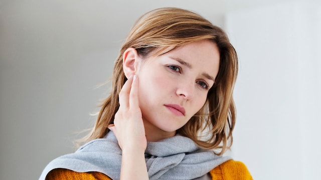 mujer con dolor en la mandíbula y el oído