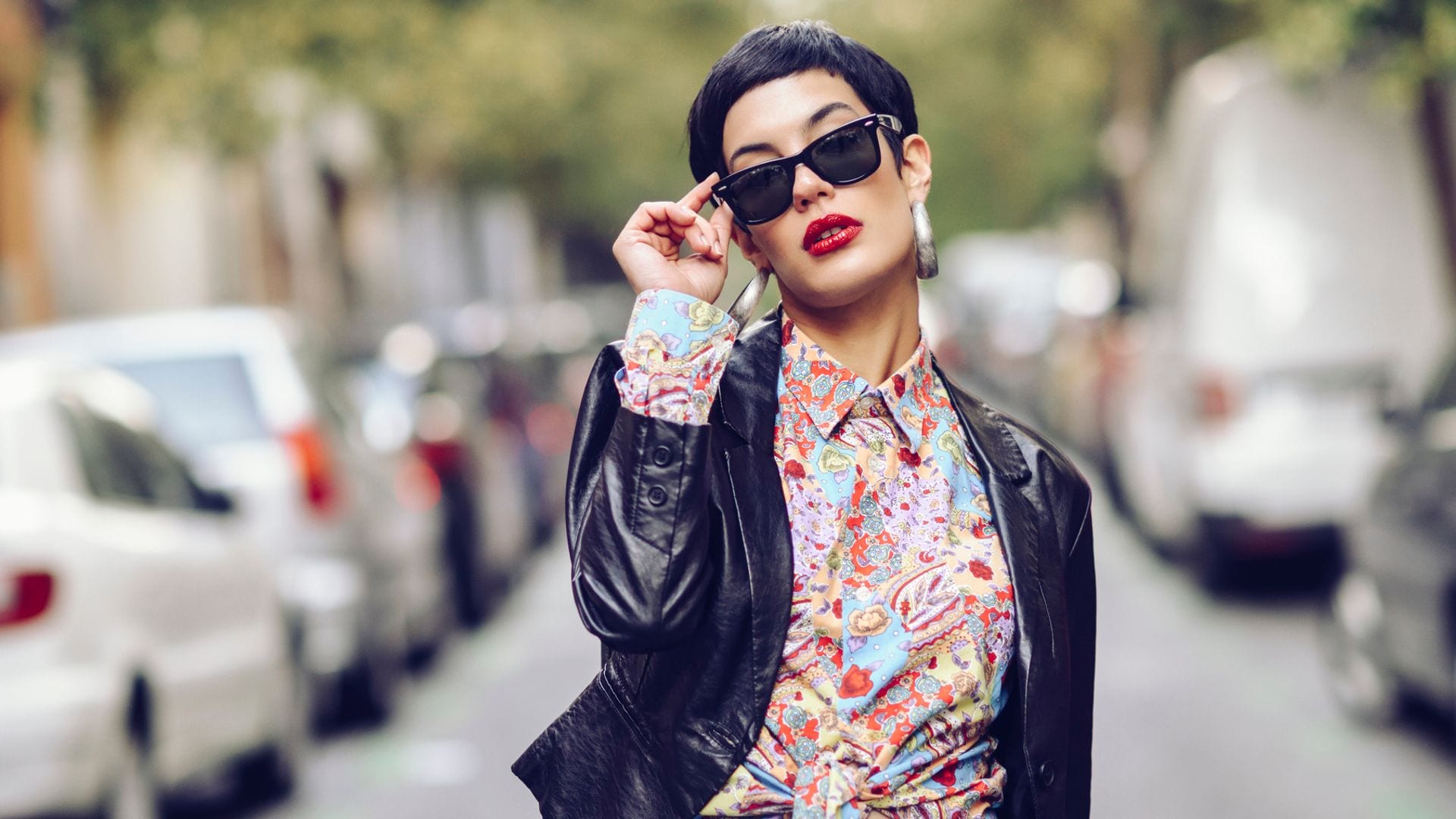 Mujer con gafas de sol caminando por la calle con gesto arrogante