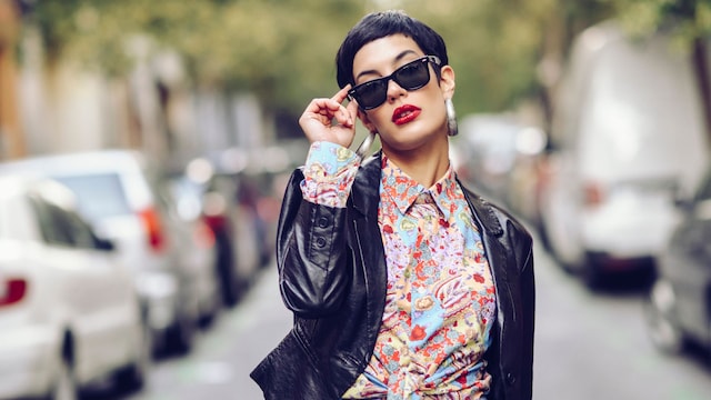 Mujer con gafas de sol caminando por la calle con gesto arrogante