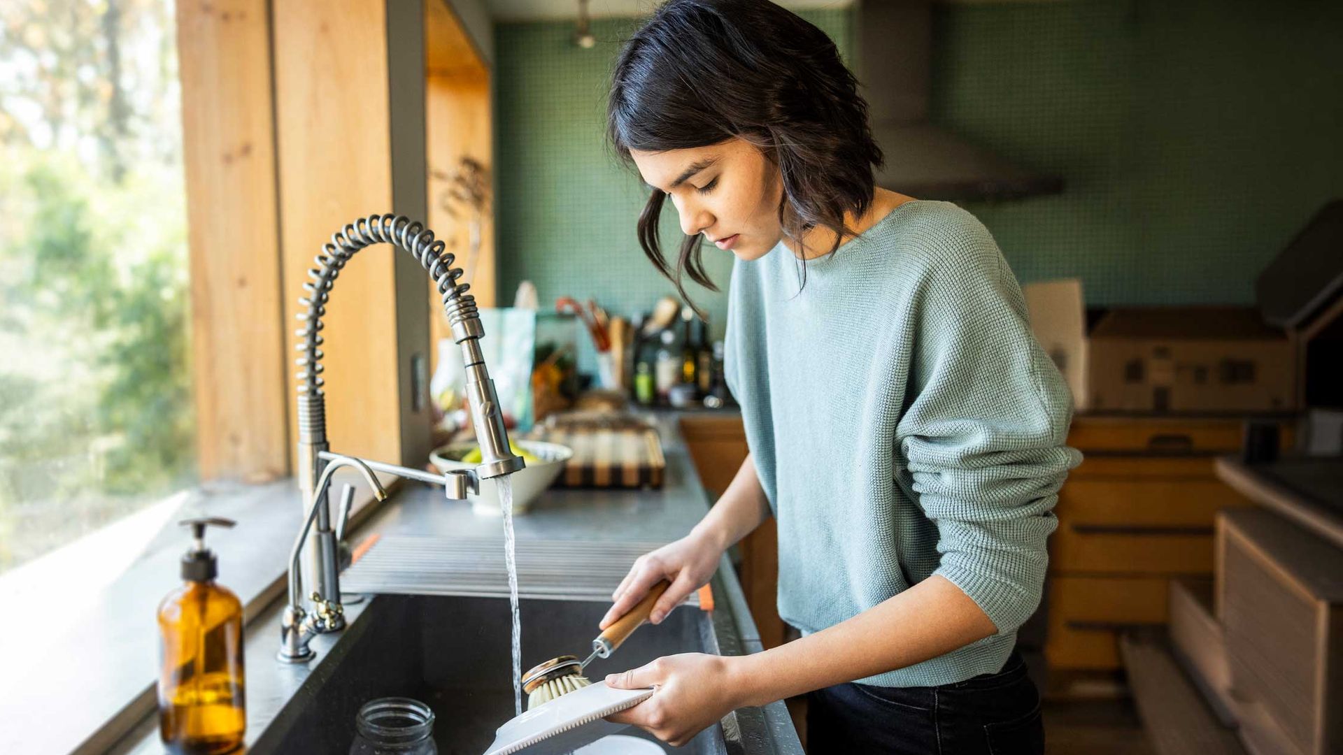 Mujer lavando los platos en la cocina