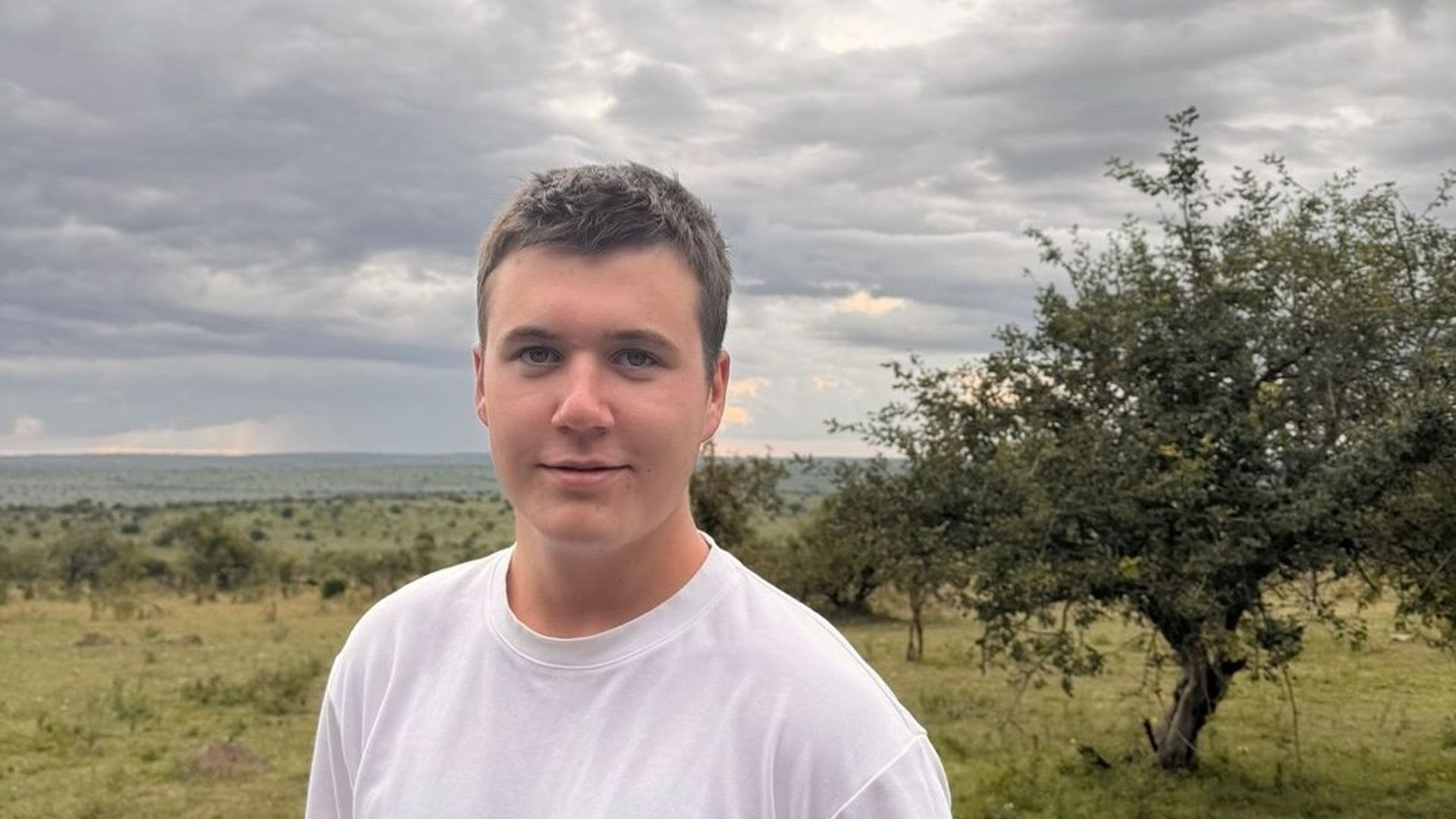 Plano medio de Christian de Dinamarca posando en el campo en África 