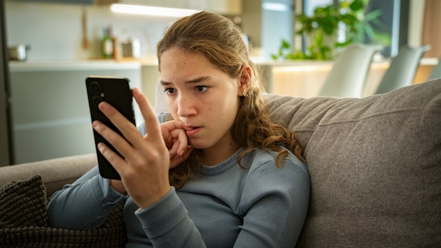 Adolescente preocupada frente al móvil