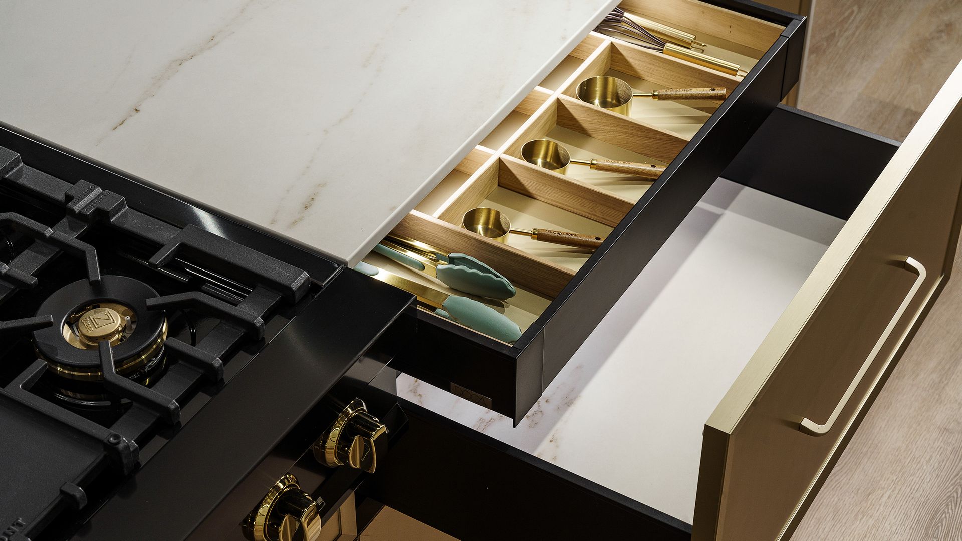 Cocina con cajón abierto con organizadores interiores de madera, placa de cocción de fuegos