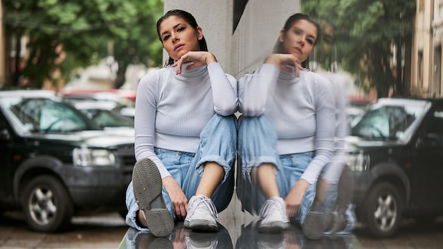 mujer relajada sentada junto a una ventana