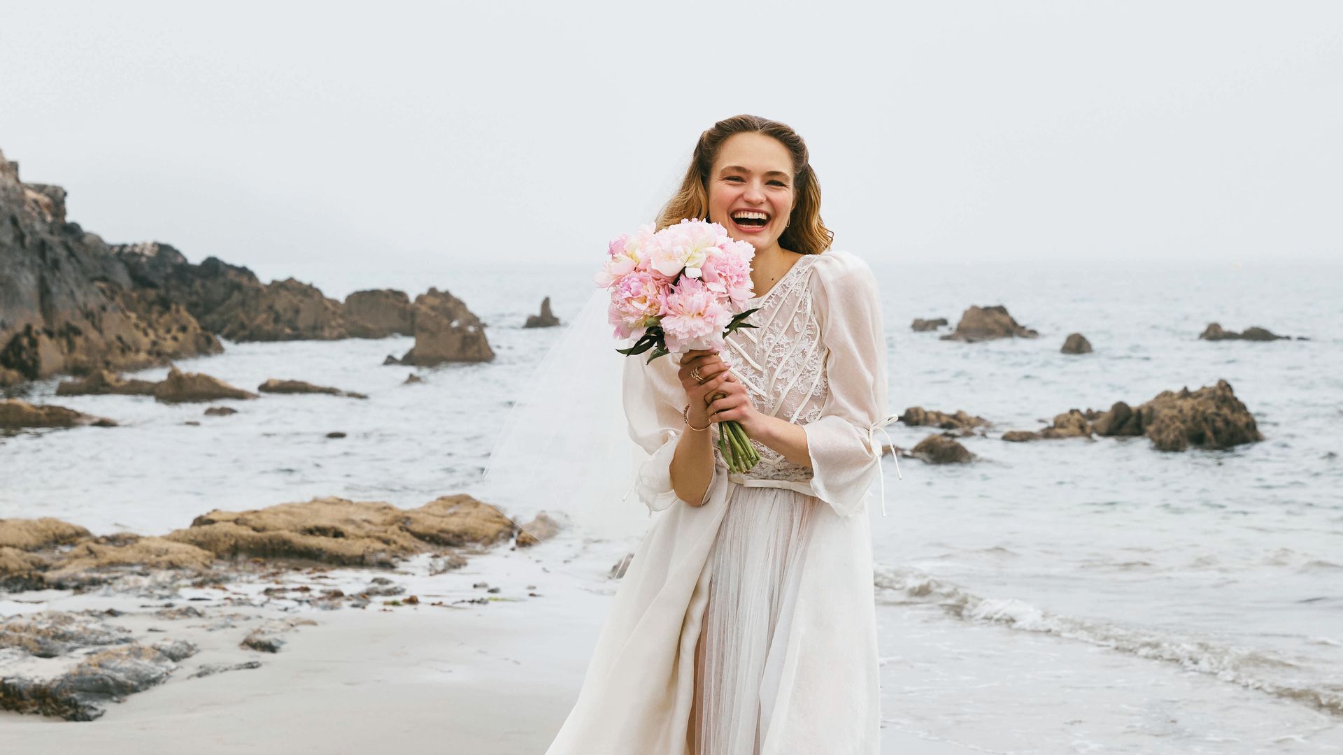 AIRES VINTAGE
Romántico y de corte retro: este look nupcial se compone de top de organza y encaje, de Laura Monge; falda de tul, de Claudia Llagostera; sobrefalda, de María Barragán; y velo corto, de Valenzuela. Como complementos, pendientes de aro en oro rosa y diamantes, de Gold & Roses; pulsera y anillos en oro rosa y diamantes, de Messika, y ramo, de Susiflor Invernaderos