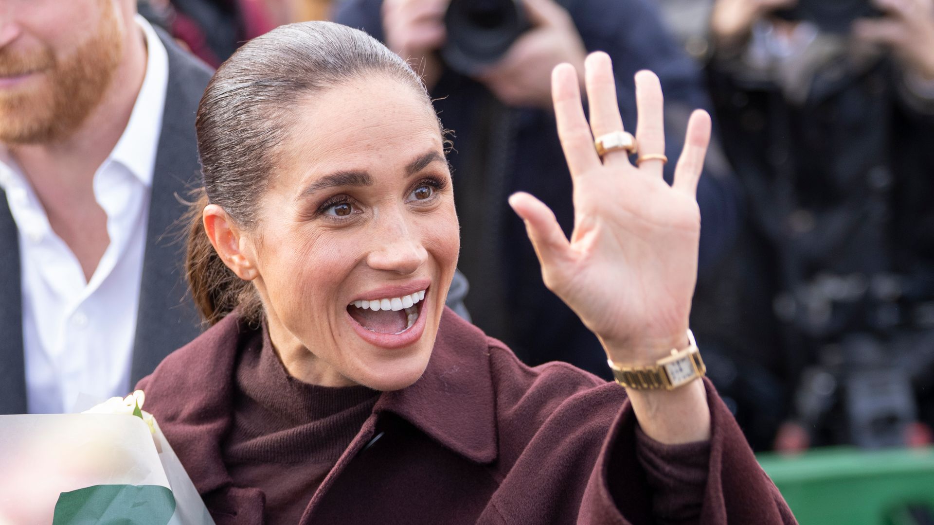 Meghan Markle, pura elegancia con un look que resume las tendencias de otoño: tonos berenjena, falda midi y abrigo de manga ancha