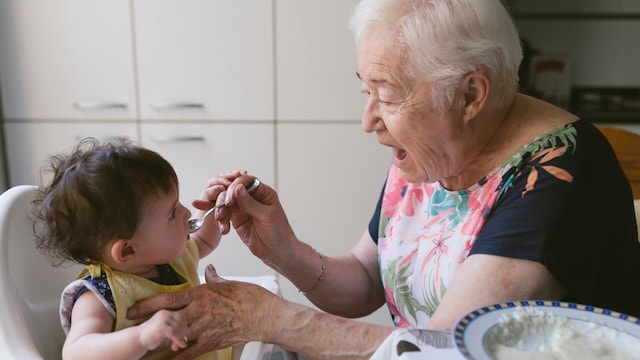 abuela da de comer a su nieta