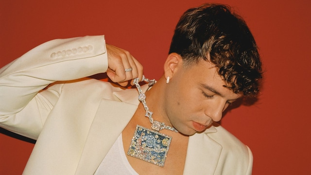Sesión de Quevedo para un album, con blazer blanca y camiseta de tirantes blanca
