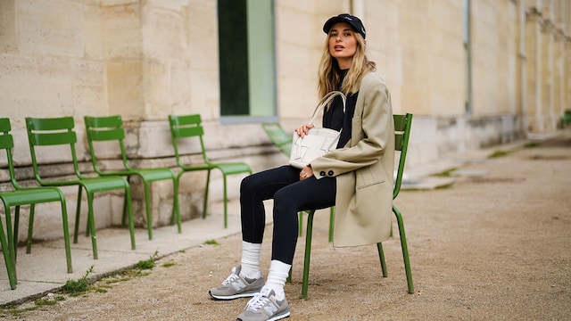 Leggings Térmicos Mujer. Mujer posando con leggings negros, zapatillas deportivas y New Balance en París
