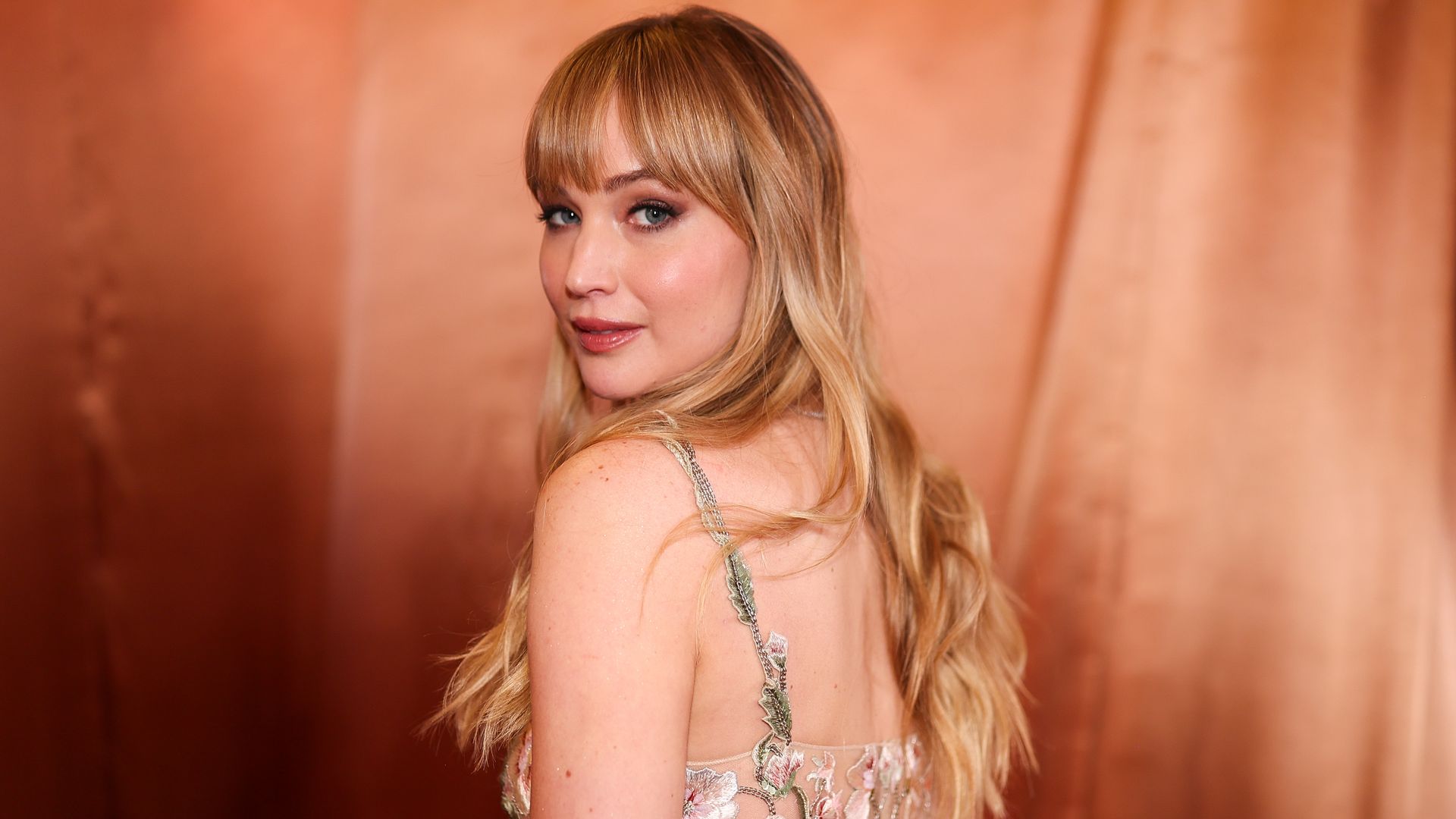 Jennifer Lawrence en los Globos de Oro 2026 de espaldas con vestido floral de Dior
