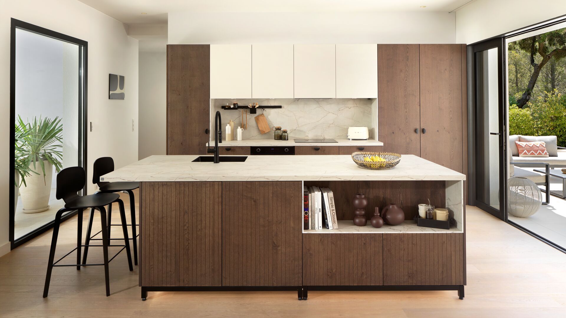 Cocina con salida al jardín, con isla con fregadero, zona de barra, armario de madera