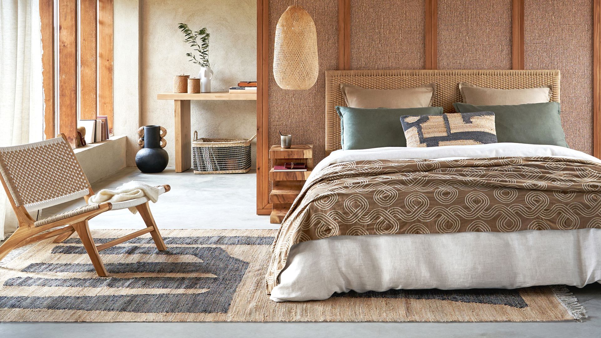 Dormitorio con cabecero de rejilla, techo de madera, alfombra de fibras vegetales, sillón de madera, armario forrado