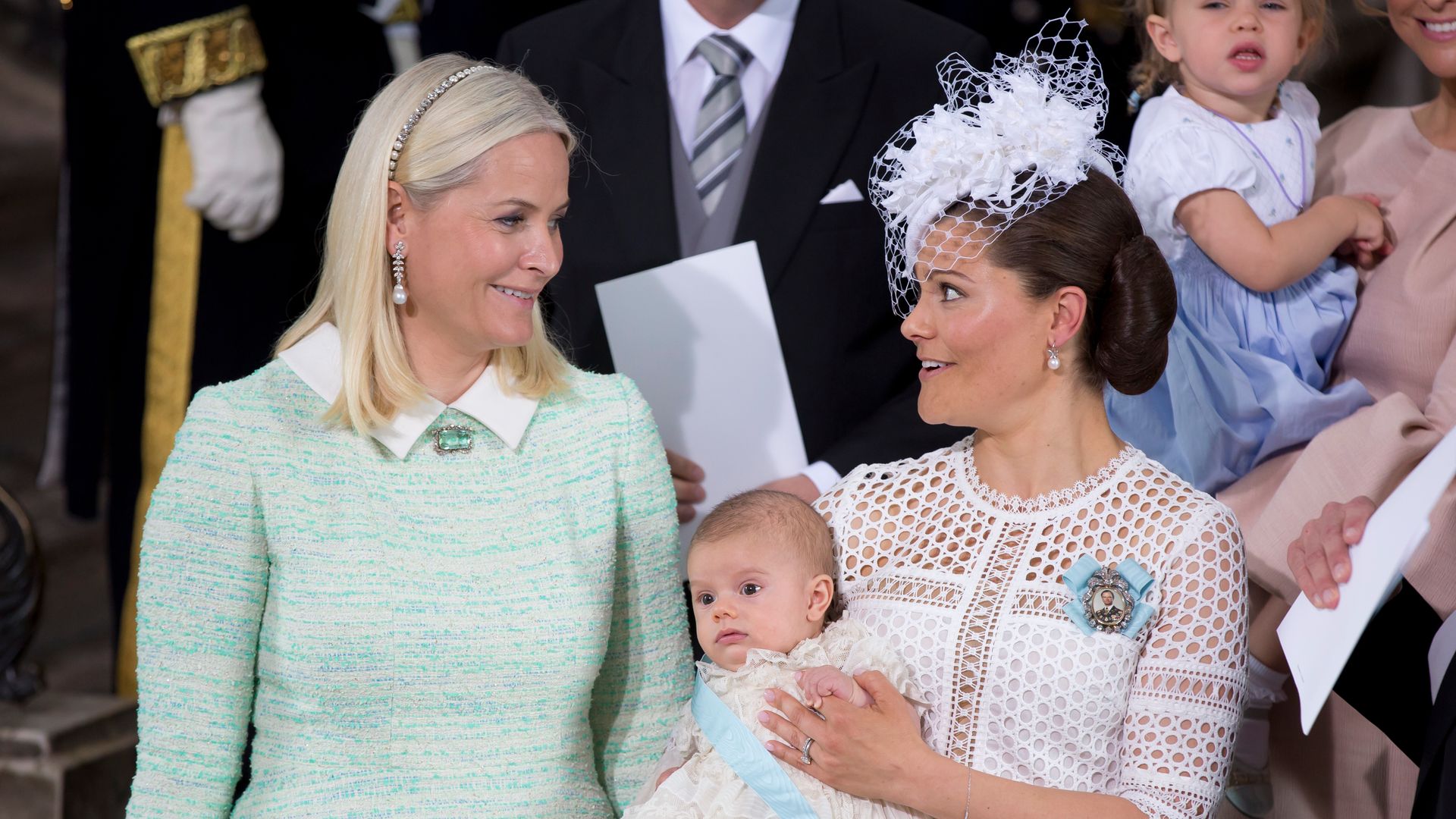 La princesa heredera Mette-Marit de Noruega junto a la princesa heredera Victoria de Suecia, quien sostiene en brazos al pequeño príncipe Osca