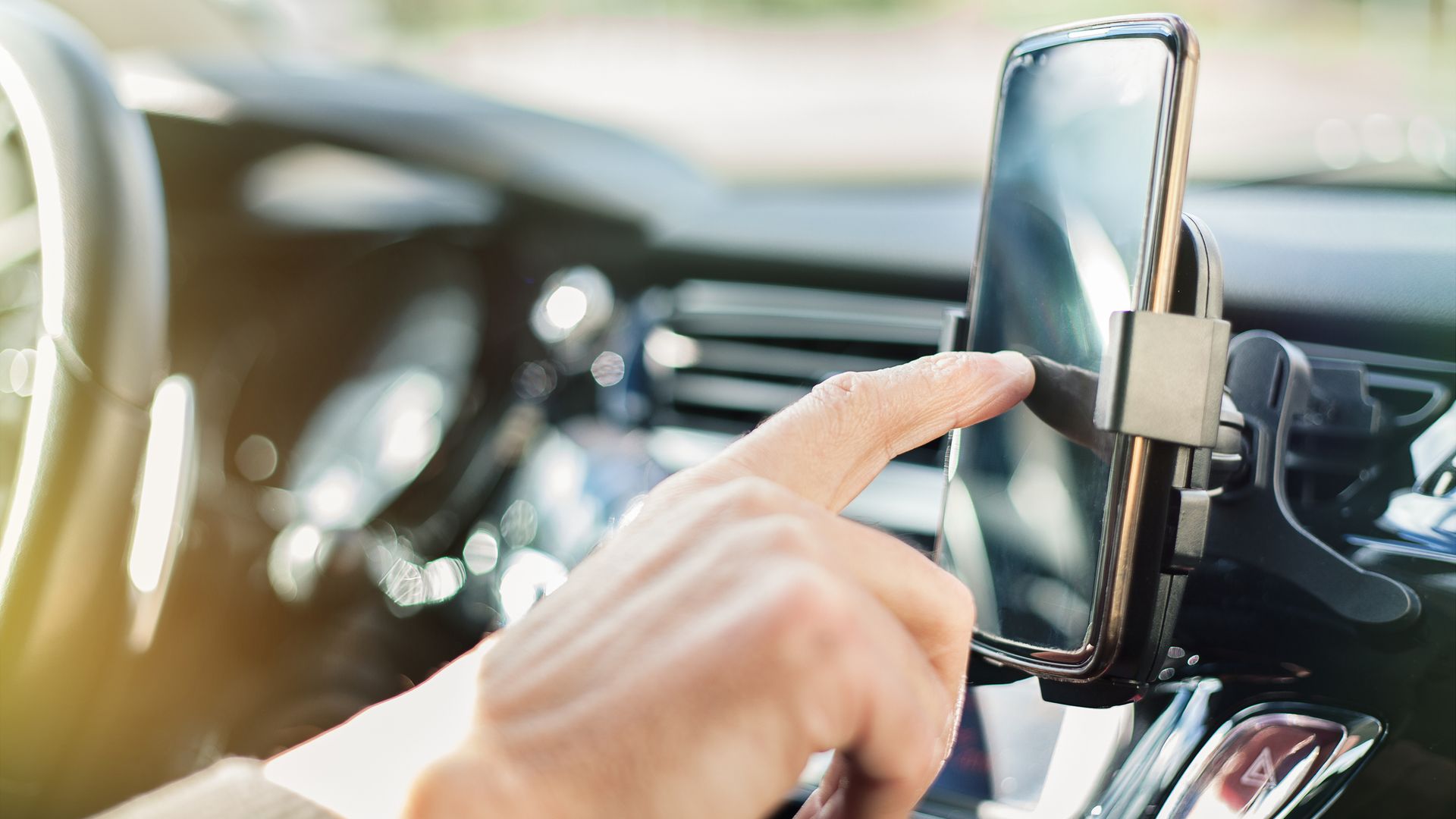 hombre usando el móvil en el coche mientras conduce
