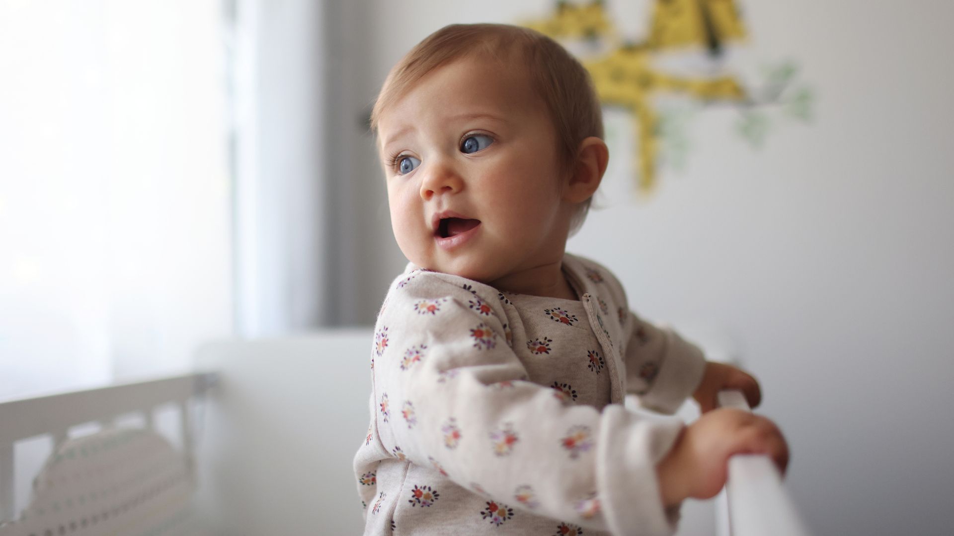 niña pequeña de pie en su cuna