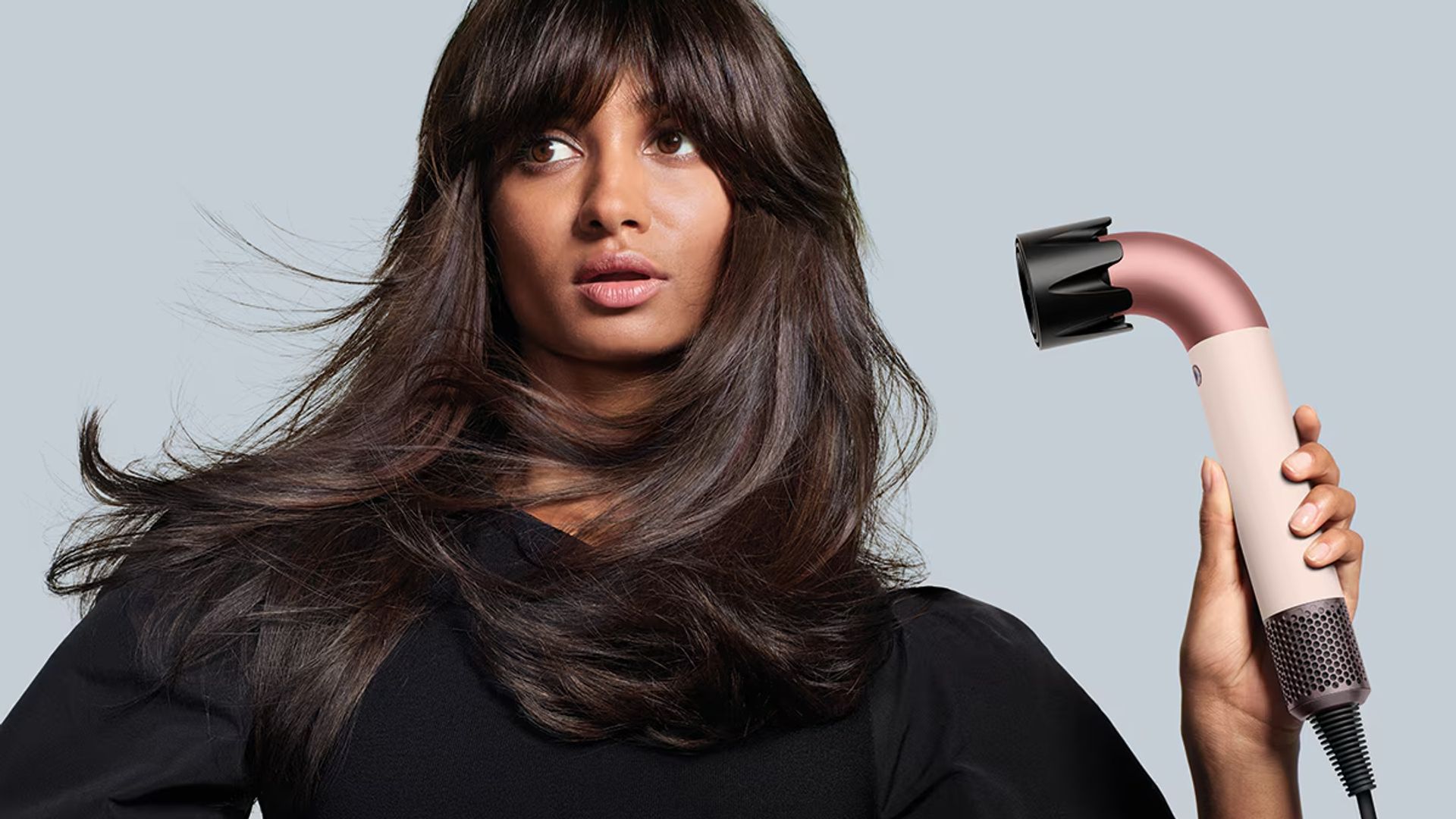 Mujer secándose el cabello con un secador de pelo de Dyson