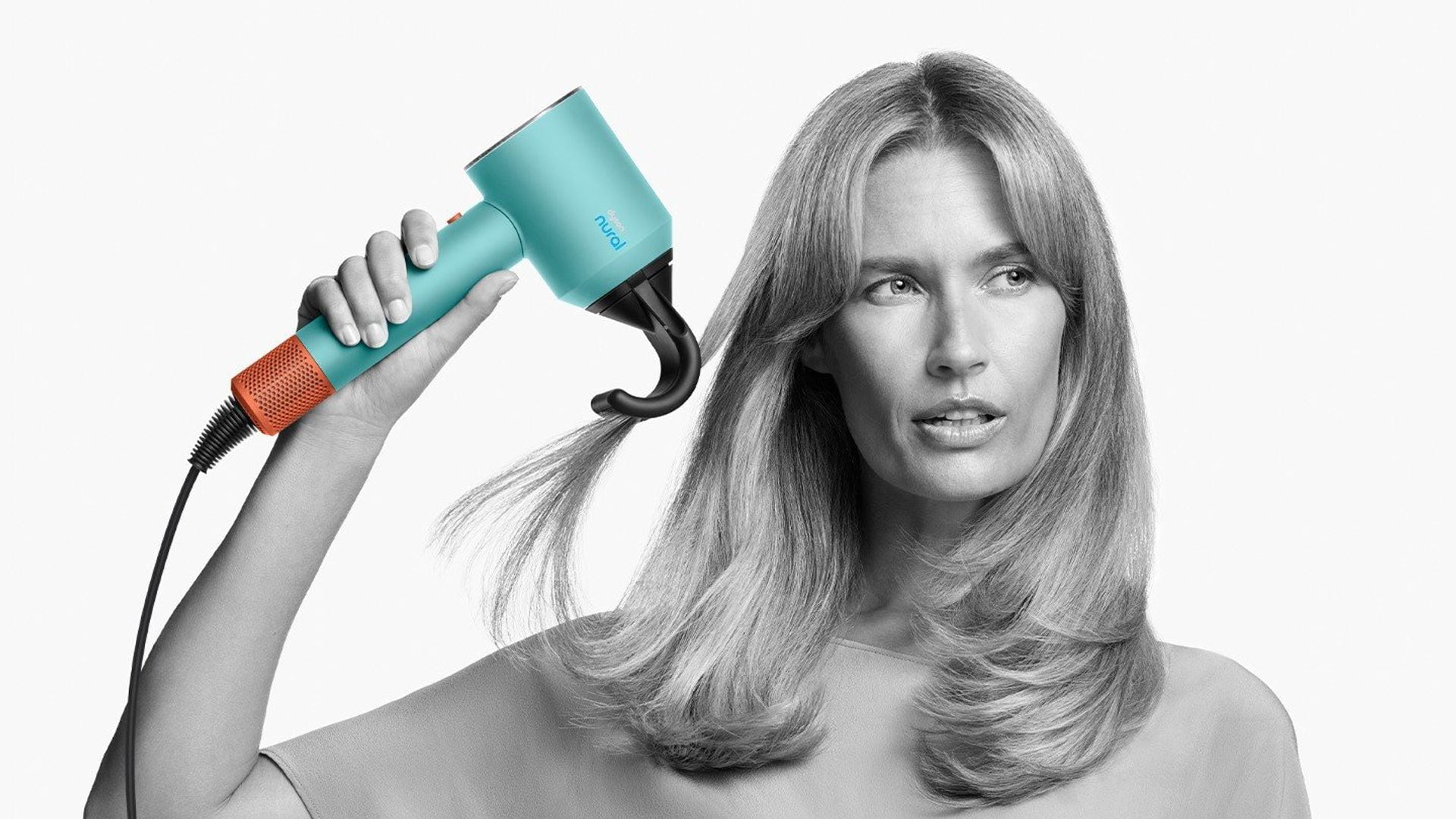 Una mujer usando el secador Dyson Nural