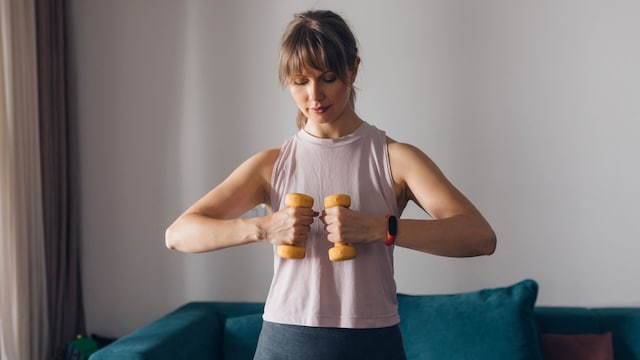 Mujer entrenando en casa con mancuernas pequeñas