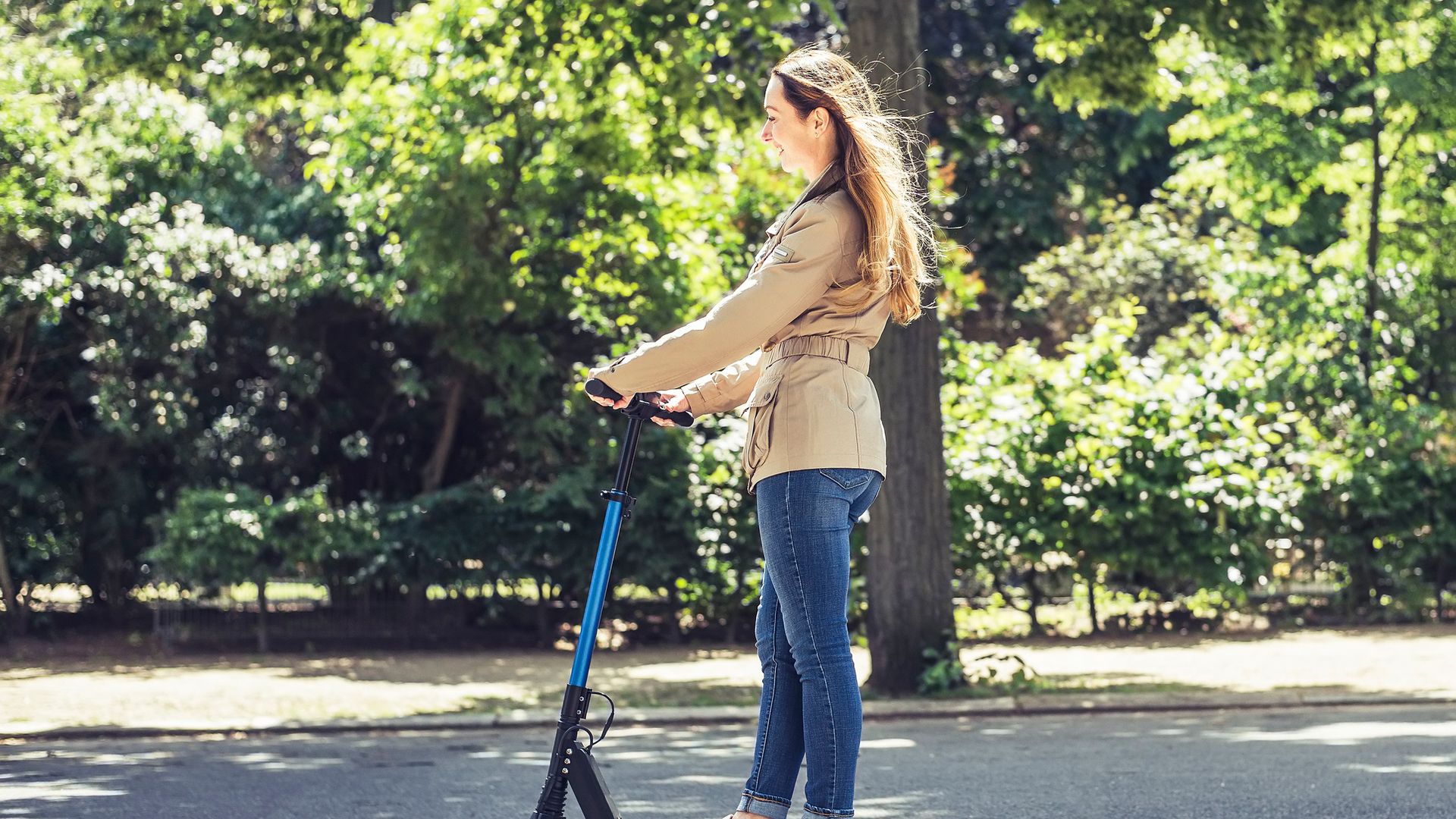 Una chica llevando un patinete eléctrico