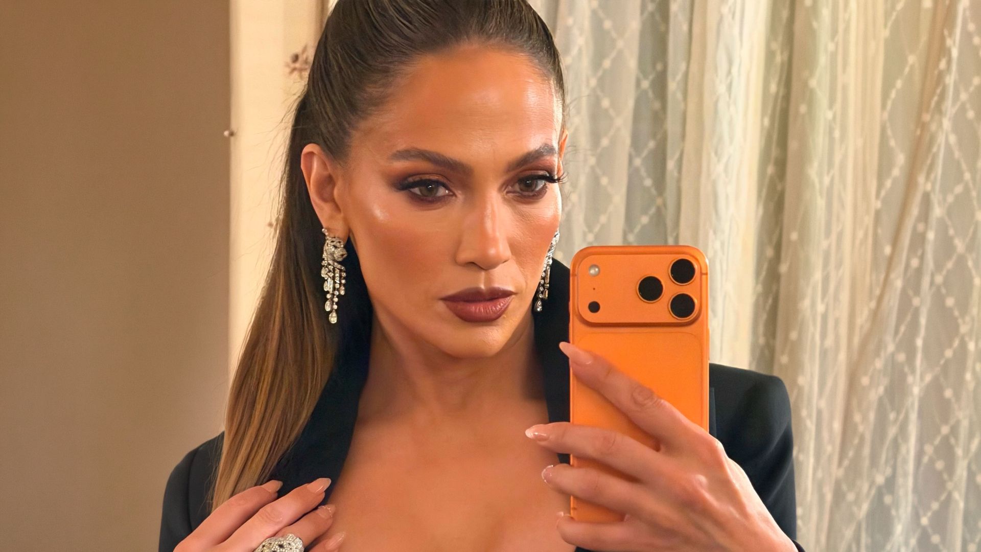 Jennifer Lopez se hace un selfie en el espejo con manicura neutra y maquillaje de otoño