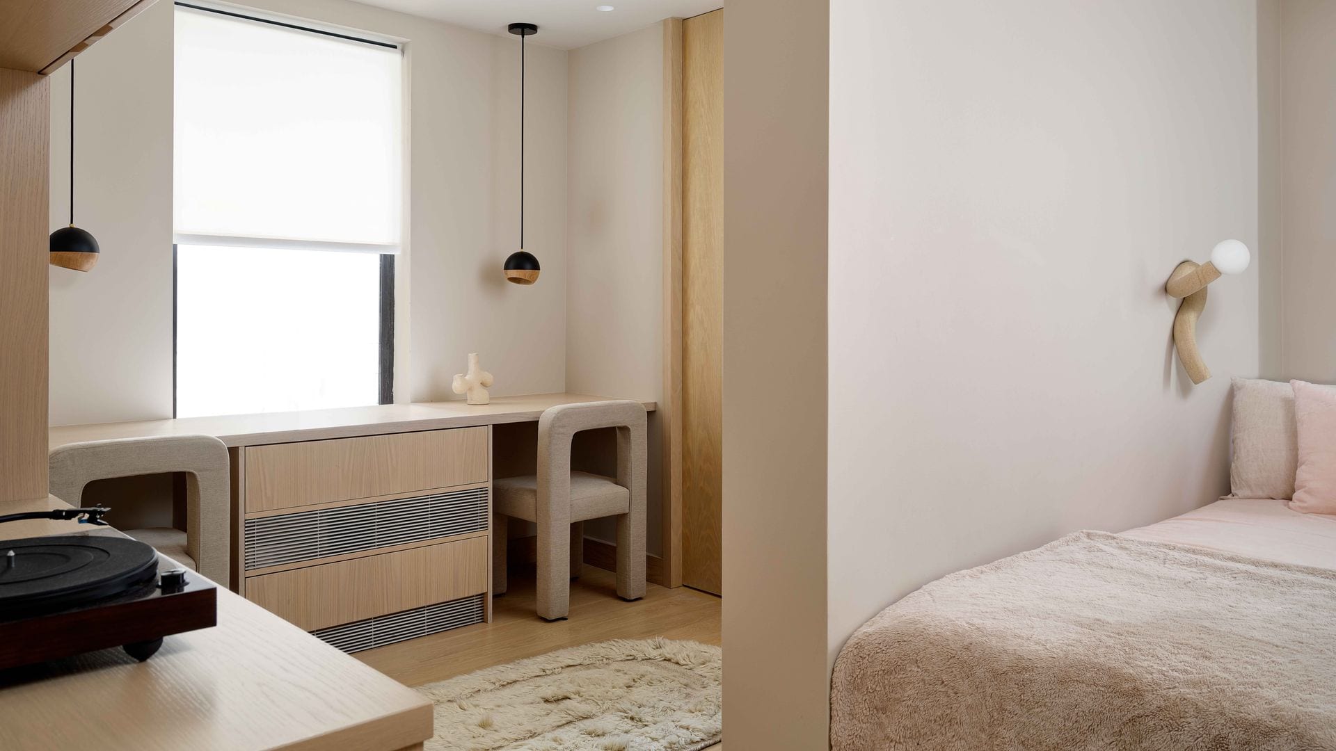 Dormitorio con zona de escritorio doble bajo la ventana, con cubrerradiador sillas, estor blanco y lámparas de techo