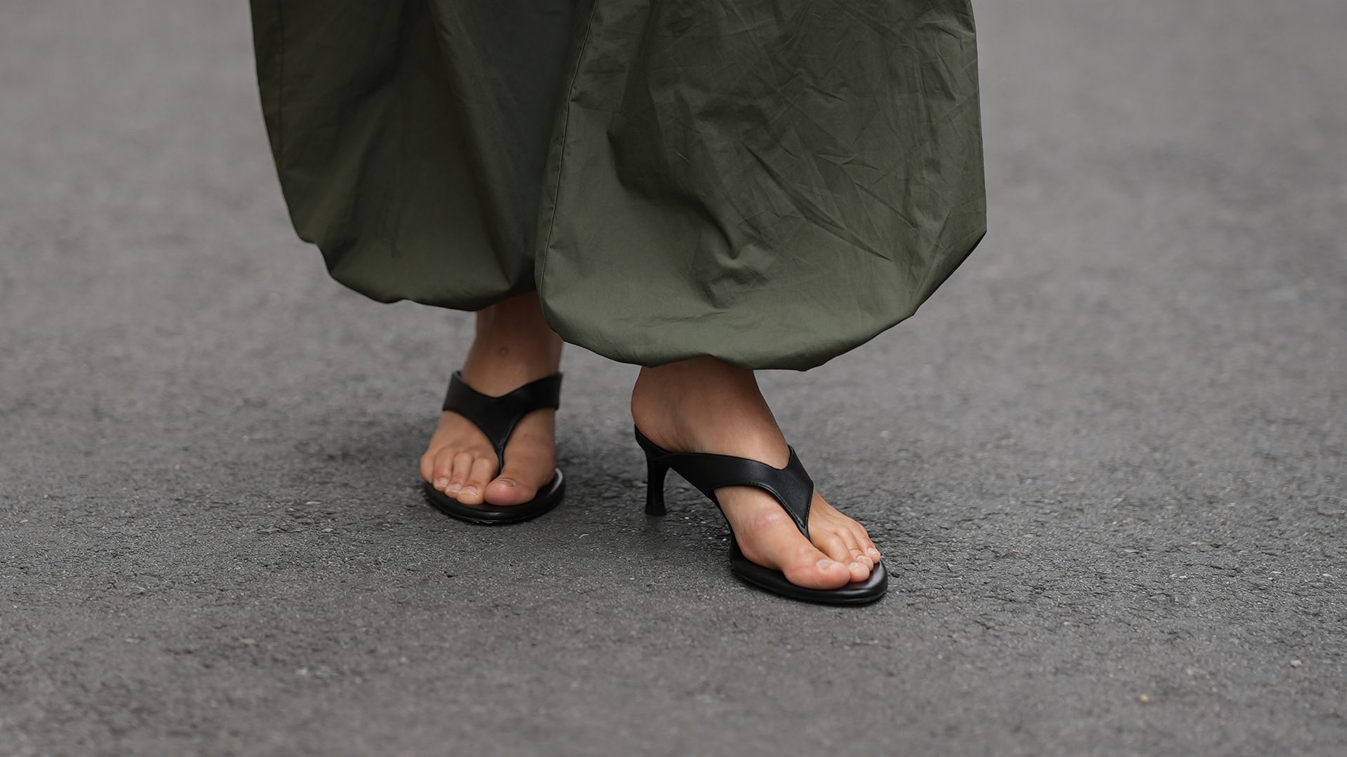 Anna Winter con pantalones bombacho verdes y sandalias de dedo con tacón bajo en Paris