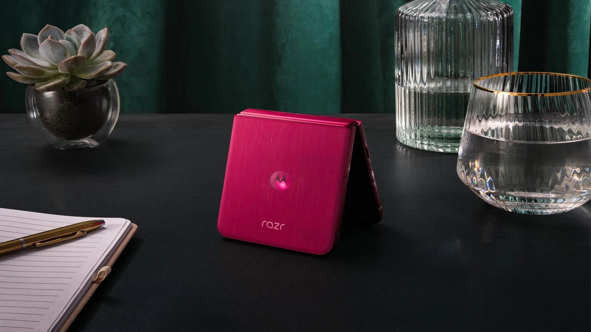 Teléfono móvil plegable Motorola Razr 60 en fucsia sobre la mesa.