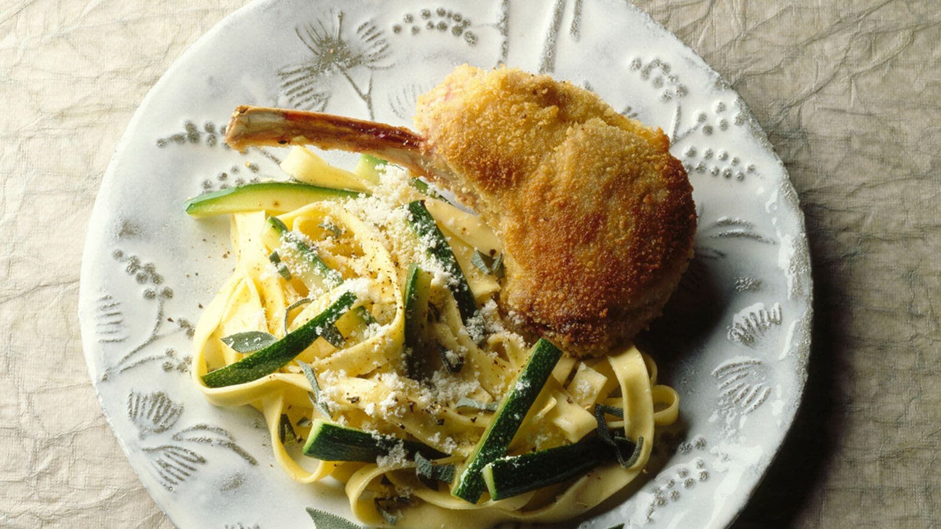 Chuletas de cordero empanadas con pasta y calabacín