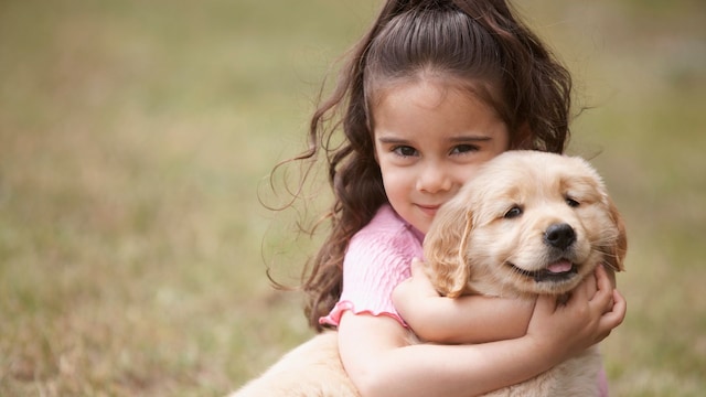Niña pequeña abraza a un perro