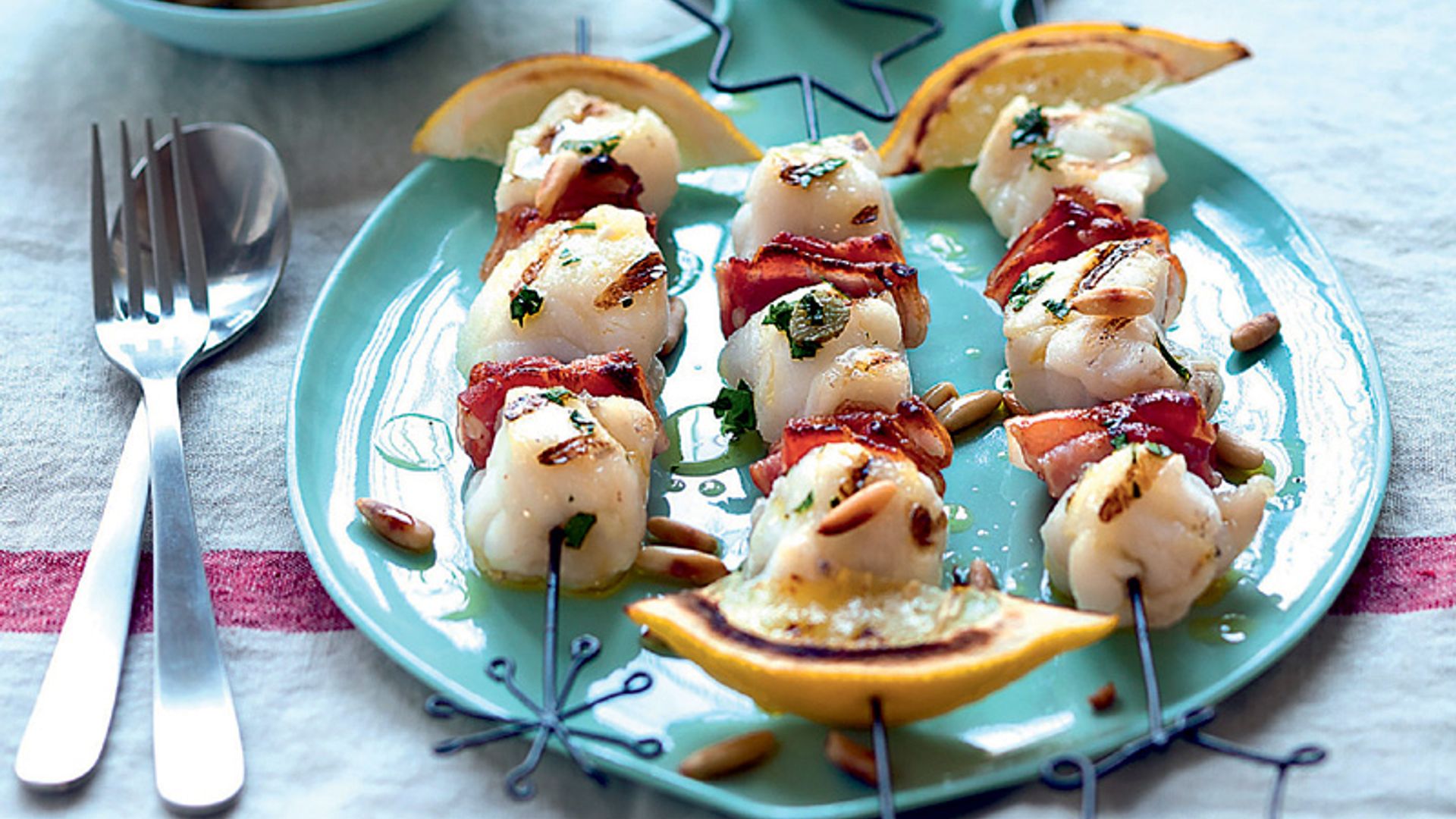 Brochetas de rape y bacon con piñones y limón