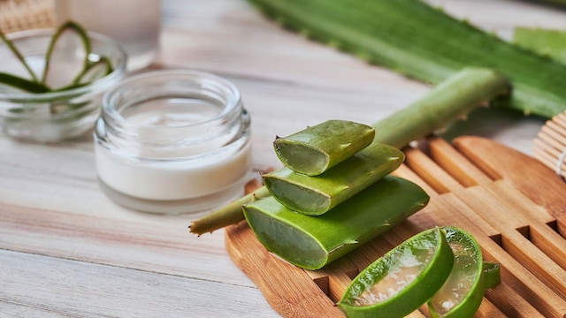 aloe vera y crema corporal en una mesa de madera