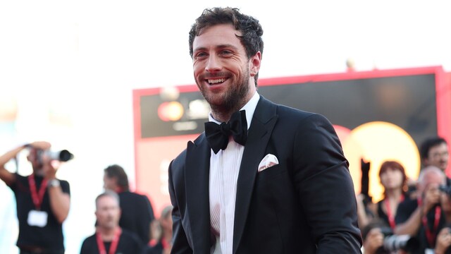 Plano medio de Aaron Taylor-Johnson con traje negro