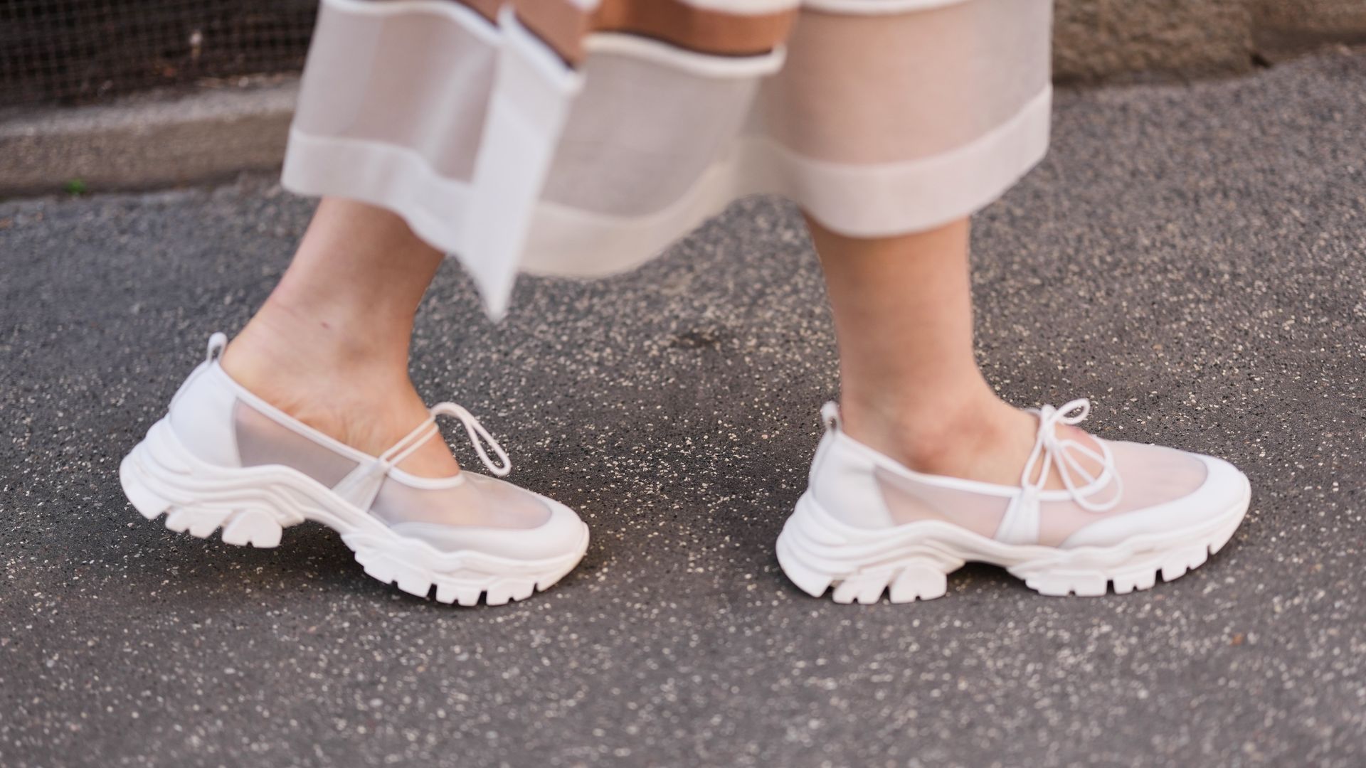 Fotografía de unos pies de mujer con zapatillas blancas tipo bailarina