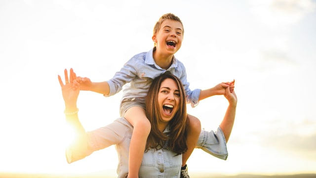 Madre con su hijo con discapacidad en los hombros