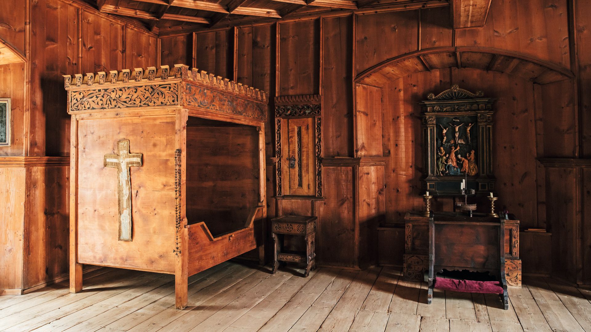 Habitación antigua con cama de madera, crucifijo, y altar