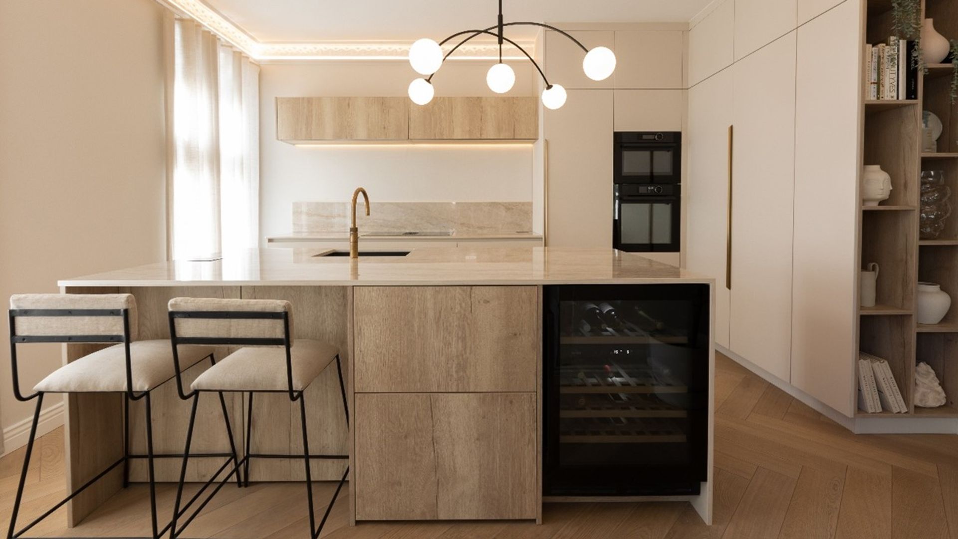 Cocina blanca con armarios hasta el techo, isla de cocina de mármol, lámpara de techo, vinoteca, iluminación perimetral 