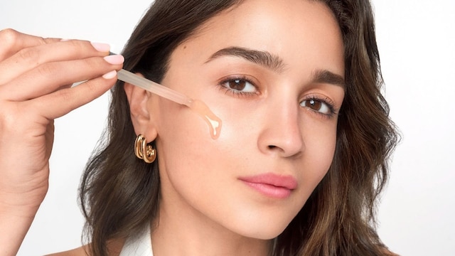 Rostro de mujer aplicándose sérum de L'Oréal con pipeta
